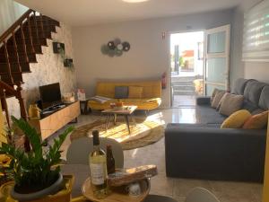 uma sala de estar com um sofá azul e uma mesa em Casa 212 em Ponta do Sol