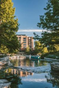 a river with a building and a boat in the water at Hotel Emma at Pearl on the Riverwalk in San Antonio