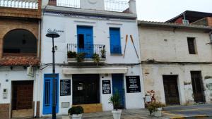 ein weißes Gebäude mit blauen Rollläden auf einer Straße in der Unterkunft Serena Moncofa in Moncófa