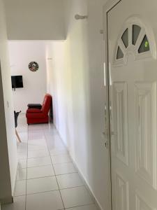 korytarz z czerwonym krzesłem i drzwiami w obiekcie Maison dans les hauteurs w mieście Le Gosier