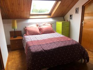 ein Schlafzimmer mit einem Bett mit rosa Kissen und einem Fenster in der Unterkunft Chelles - Paris - Disneyland Marne la vallée in Chelles