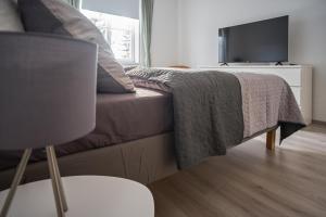 巴登的住宿－revLIVING Apartment Quintus Baden City Center，一间卧室配有一张床铺,床上有毯子