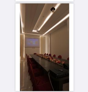 una sala de conferencias con una mesa larga y sillas rojas en فندق سكاي لاين, 