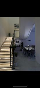 una escalera en una habitación con mesa y sillas en شاليه اند هوم, en Hail
