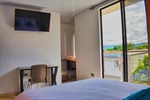 um quarto com uma cama e uma grande janela em Hotel El Sol Inn em Aguachica