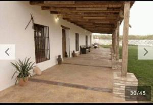 un porche de una casa blanca con techo de madera en Casa Rural Huerta Los Caños, en Bienvenida
