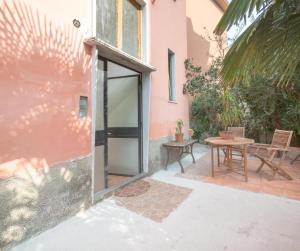 Pioltello的住宿－Villa verdi vicinanze Milano centro，粉红色房子的大门,带桌子