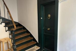 un escalier avec une porte verte à côté d'un escalier. dans l'établissement Charming apartment in the heart of Paris, à Paris