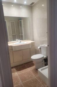 a bathroom with a toilet and a sink and a mirror at Amplio apartamento in Puebla de Farnals