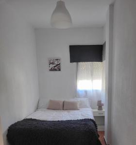 a bedroom with a bed in a white room at Amplio apartamento in Puebla de Farnals