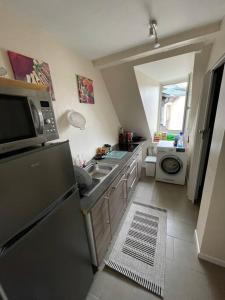 a small kitchen with a sink and a microwave at Joli 2 pièces - Krutenau Austerlitz in Strasbourg +5 photos