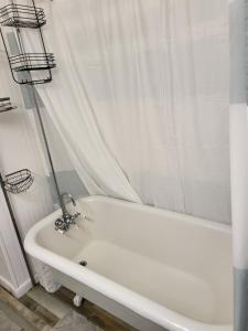 d'une baignoire blanche avec rideau de douche. dans l'établissement Historic GWALTNEY HOUSE-Cottage at St Andrew's Bay, à Panama City 34 autres photos