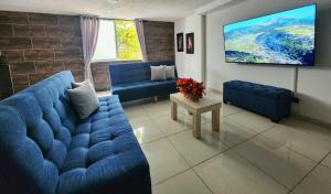 卡利的住宿－Apartamento en el Peñón - Oeste，客厅配有蓝色的沙发和平面电视。