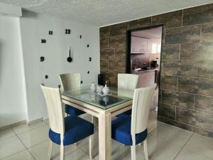卡利的住宿－Apartamento en el Peñón - Oeste，一间设有玻璃桌和椅子的用餐室