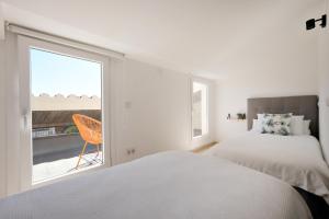 1 dormitorio con cama y ventana grande en Apartamento dúplex Catalunya, en Sant Antoni de Calonge