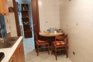 uma cozinha com uma mesa e cadeiras e um lavatório em Appartamento Adriano em Crescenzago