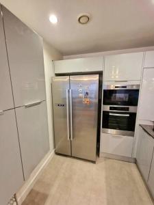 uma cozinha com um frigorífico e electrodomésticos em aço inoxidável em Amazing flat in the heart of Manchester city centre! em Manchester