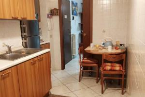 uma cozinha com um lavatório e uma mesa com cadeiras em Appartamento Adriano em Crescenzago