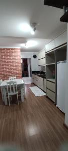 cocina con mesa y nevera en una habitación en Sobrado para temporada, en Camboriú