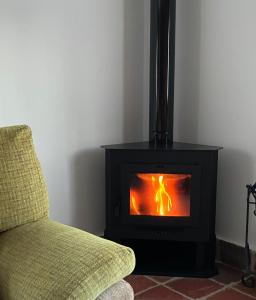 a fireplace in a living room with a couch and a fire at El Busque Casa Rural in Casla