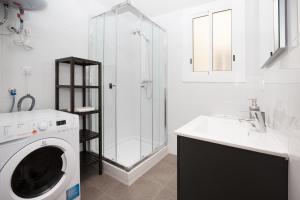 ein weißes Badezimmer mit einer Waschmaschine und einem Waschbecken in der Unterkunft Park Guell in Barcelona
