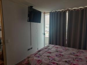 1 dormitorio con cama y ventana en MATIZ CAVANCHA en Iquique