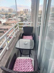 einen Tisch und Stühle auf einem Balkon mit Aussicht in der Unterkunft MATIZ CAVANCHA in Iquique