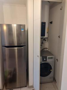 eine Küche mit einer Waschmaschine und einem Kühlschrank in der Unterkunft MATIZ CAVANCHA in Iquique