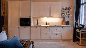 a kitchen with white cabinets and a sink at Villa Maija 2 Southside in Hanko +15 photos