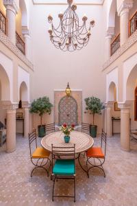 a large room with a table with chairs and a chandelier at Riad Dar Azal in Marrakesh