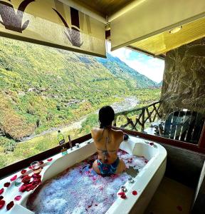 a child sitting in a bath tub with a view at Aldea Real Eco Friendly in Baños