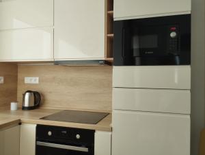 a kitchen with a microwave oven and a stove at New apartman Sali in Galanta