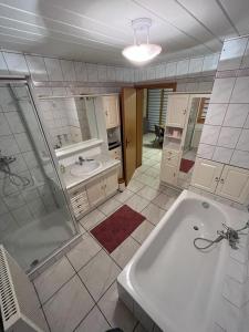 a bathroom with a tub and a shower and a sink at Gite L'arrière in Rouffach