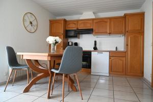 a kitchen with wooden cabinets and a wooden table and chairs at Gite L'arrière in Rouffach