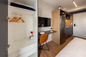 a small bedroom with a bed and a desk at Charlie Nik Vila Mariana in Sao Paulo