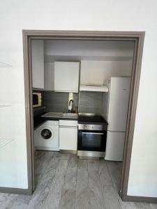 a small kitchen with white appliances and a refrigerator at Grand studio Nice centre in Nice