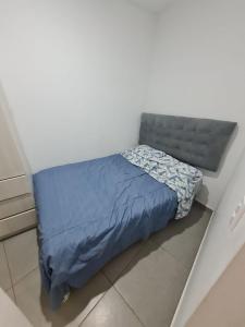 uma cama com um edredão azul num quarto em Departamento de Playa (con piscina propia) en km 107 Asia, Lima em Asia