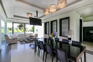 萬隆的住宿－Villa DagoResor Kanata 7BR 45peop Private Infinity Pool & Roof Garden，用餐室以及带桌椅的起居室。