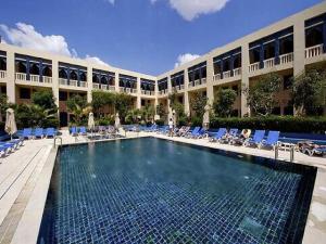 une piscine en face d'un grand bâtiment dans l'établissement Diar Lemdina Hotel, à Hammamet