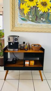 a shelf with a coffee maker and a painting at Edifício Ocean garden in São Luís