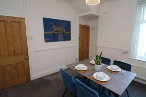 a dining room with a table and blue chairs at 2 Bedroom Characterful House in Lancaster
