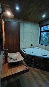 a large bathroom with a tub with a hammock in it at Cabaña Luna Encantada in Mazamitla