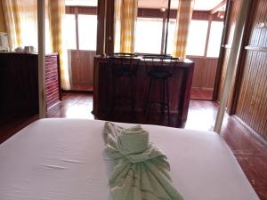 Una cama blanca con un arco en una habitación en Hotel Green Mountain, en Turrialba