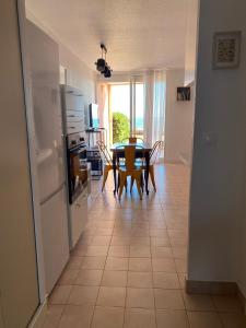Una cocina y un comedor con mesa y sillas. en SèteÔSoleil, en Sète