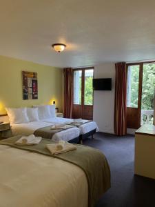 a hotel room with two beds and a flat screen tv at HOTEL & SPA GASQUET in Luchon