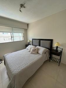 una camera da letto con un letto con due cuscini sopra di Apartamento playa el Emir a Punta del Este