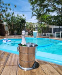 a bucket with a towel in it next to a swimming pool at Pousada Recanto de Praia Seca in Araruama