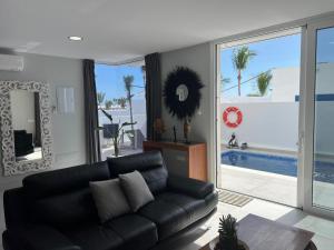 a living room with a black leather couch and a pool at Beach Paradise in Tías