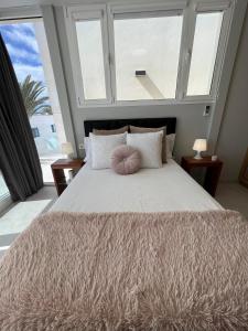 a bedroom with a large bed with a large window at Beach Paradise in Tías +26 photos