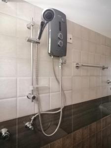un teléfono en la pared de una ducha en el baño en White House, en Weligama